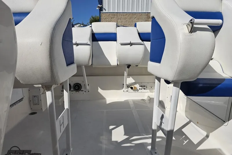 Slide: The Image of Interior of a 2002 Hustler 388 SLINGSHOT boat with white and blue seating. - 82