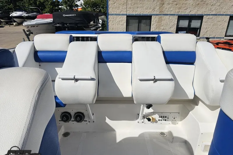Slide: The Image of 2002 Hustler 388 SLINGSHOT boat interior with white and blue seating. - 86