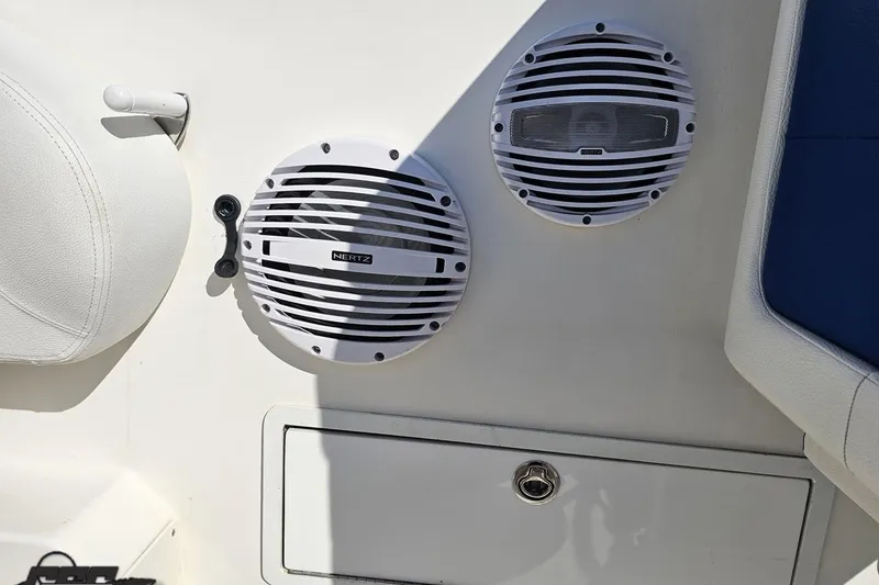 Slide: The Image of Speakers on a 2002 Hustler 388 SLINGSHOT boat interior, featuring white and blue seating. - 90