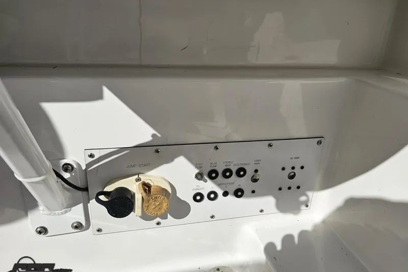 Slide: The Image of Control panel of a 2002 Hustler 388 SLINGSHOT boat with various switches and connectors. - 95