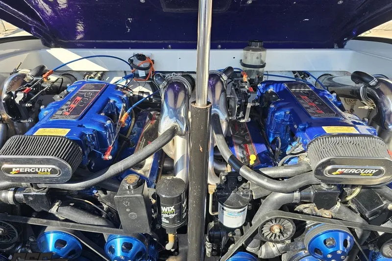 Slide: The Image of Twin Mercury Racing engines in a 2002 Hustler 388 SLINGSHOT boat, showcasing high-performance power. - 98