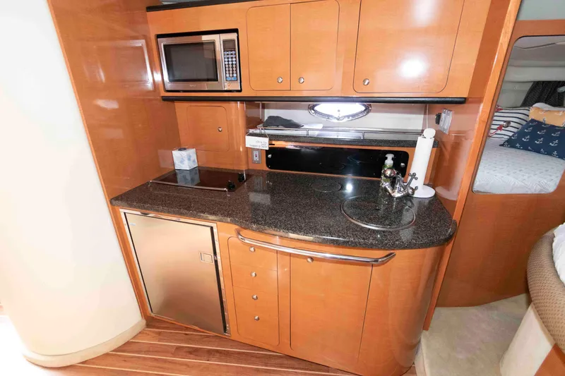 Slide: The Image of 2007 Chaparral Signature 350 yacht interior with kitchenette, featuring microwave and compact fridge. - 12