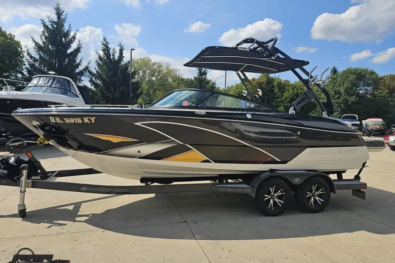 Slide: The Image of 2018 Monterey 238SS Super Sport boat on trailer, parked outdoors under blue sky. - 11