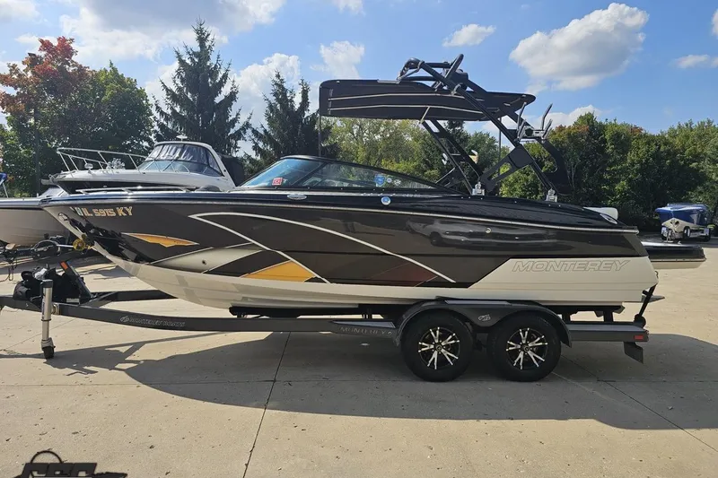 Slide: The Image of 2018 Monterey 238SS Super Sport boat on trailer, parked outdoors under a blue sky. - 12
