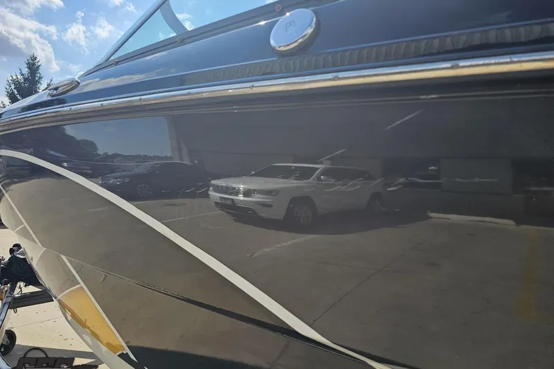 Slide: The Image of 2018 Monterey 238SS Super Sport boat reflecting parked cars under a sunny sky. - 27
