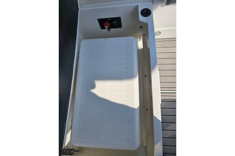 Slide: The Image of 2018 Monterey 238SS Super Sport boat storage compartment with Igloo cooler and control panel. - 73