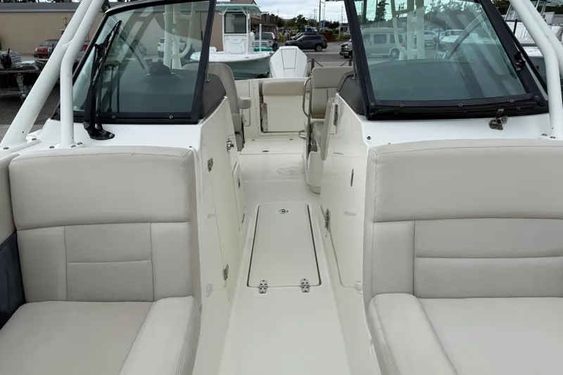 Slide: The Image of 2019 Boston Whaler 230 Vantage boat interior on calm water, showcasing seating and helm. - 16