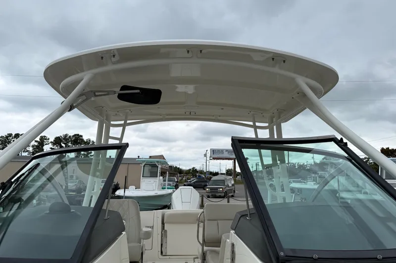 Slide: The Image of 2019 Boston Whaler 230 Vantage boat interior on calm water, showcasing seating and helm. - 17