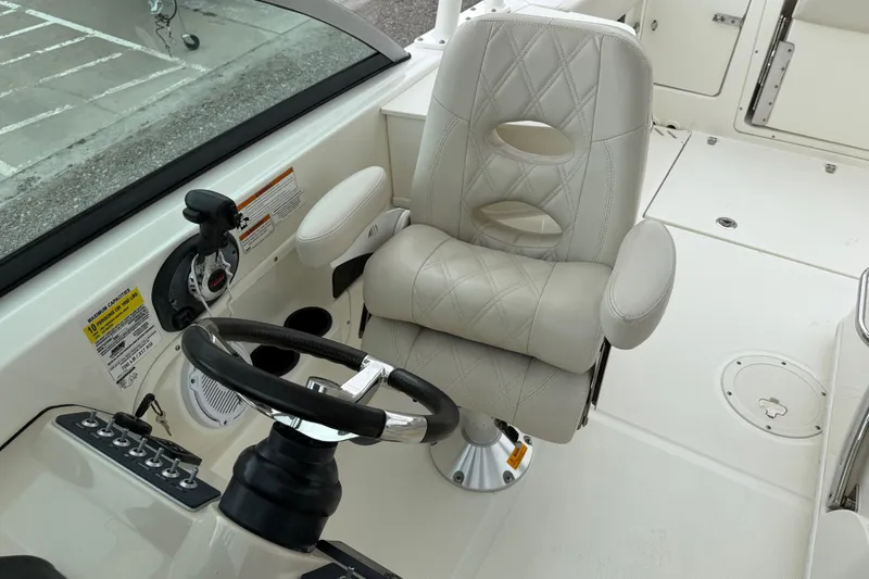 Slide: The Image of 2019 Boston Whaler 230 Vantage boat interior with seating and storage, near waterfront homes. - 18