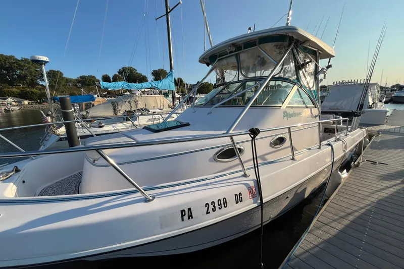 Slide: The Image of 1994 Pro-Line 2950 boat docked at marina, sunny day, fishing rods visible. - 0