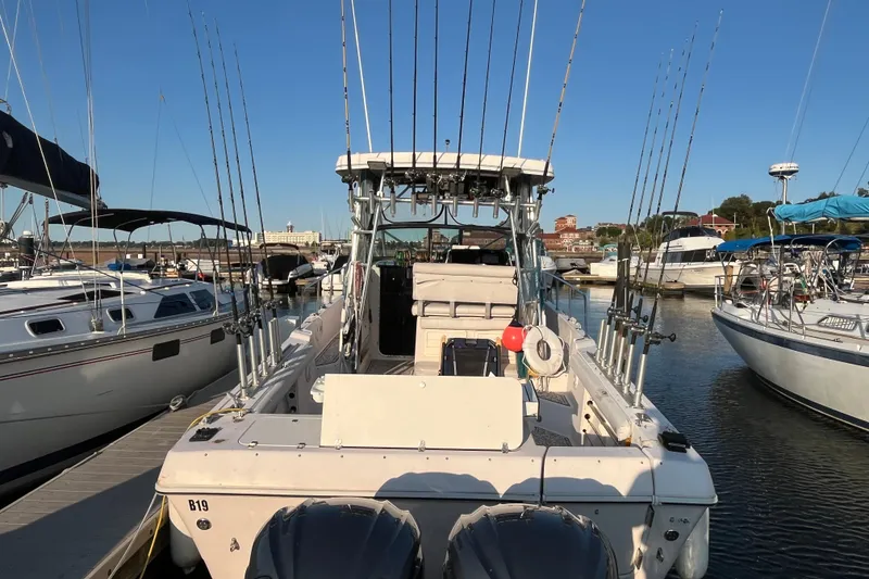 Slide: The Image of 1994 Pro-Line 2950 boat docked, equipped with multiple fishing rods, in a marina setting. - 14