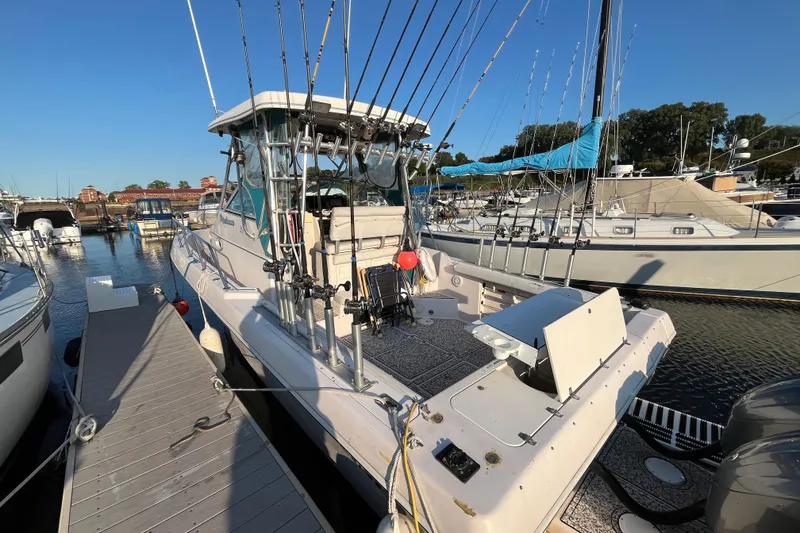 Slide: The Image of 1994 Pro-Line 2950 boat docked, equipped with fishing rods, in a marina setting. - 15