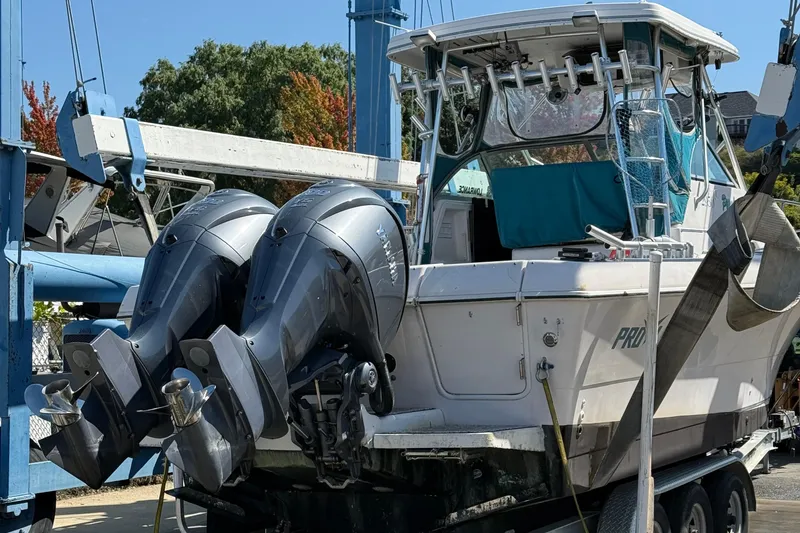 Slide: The Image of 1994 Pro-Line 2950 boat with dual outboard motors on a trailer. - 2