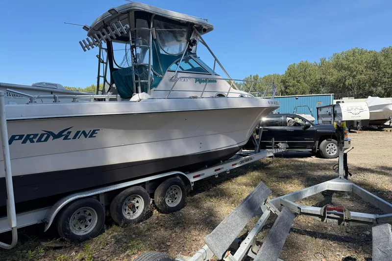 Slide: The Image of 1994 Pro-Line 2950 boat on trailer, parked outdoors near a black truck. - 4