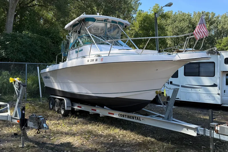 Slide: The Image of 1994 Pro-Line 2950 boat on trailer, parked outdoors with American flag. - 5