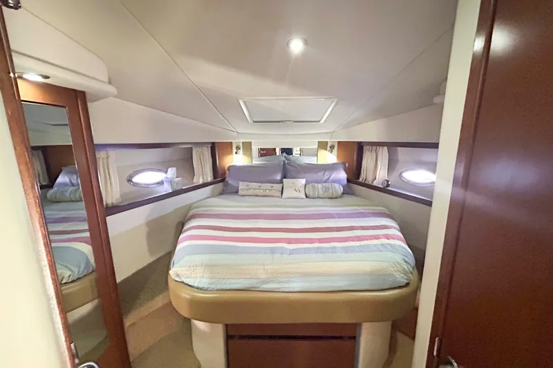 Slide: The Image of Luxurious cabin interior of 2008 Sea Ray 38 Sundancer yacht with cozy bed and porthole windows. - 11