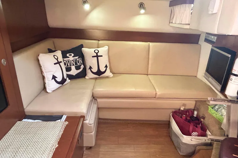 Slide: The Image of Interior of 2008 Sea Ray 38 Sundancer with beige seating and nautical-themed pillows. - 12
