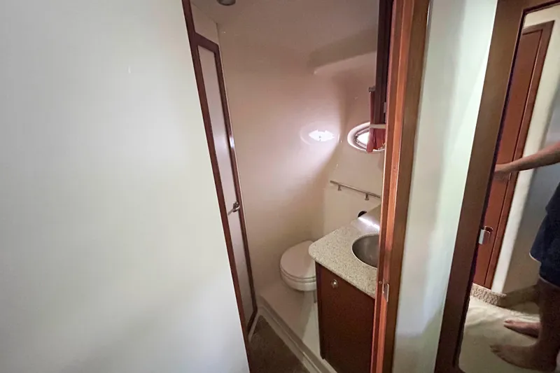 Slide: The Image of 2008 Sea Ray 38 Sundancer bathroom with sink, toilet, and wooden cabinetry. - 13
