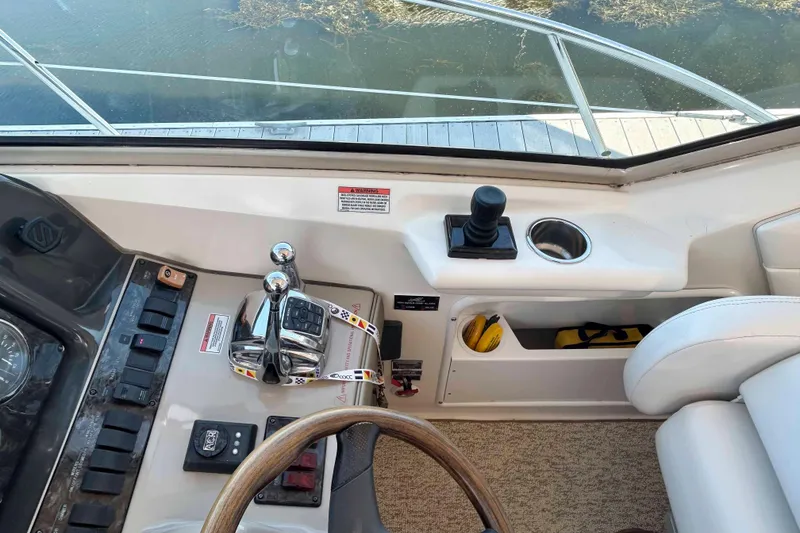 Slide: The Image of 2008 Sea Ray 38 Sundancer helm with controls, steering wheel, and cup holder. - 5