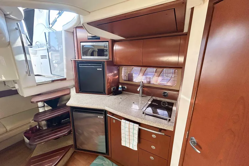 Slide: The Image of 2008 Sea Ray 38 Sundancer yacht interior kitchen with modern appliances and wooden cabinetry. - 8