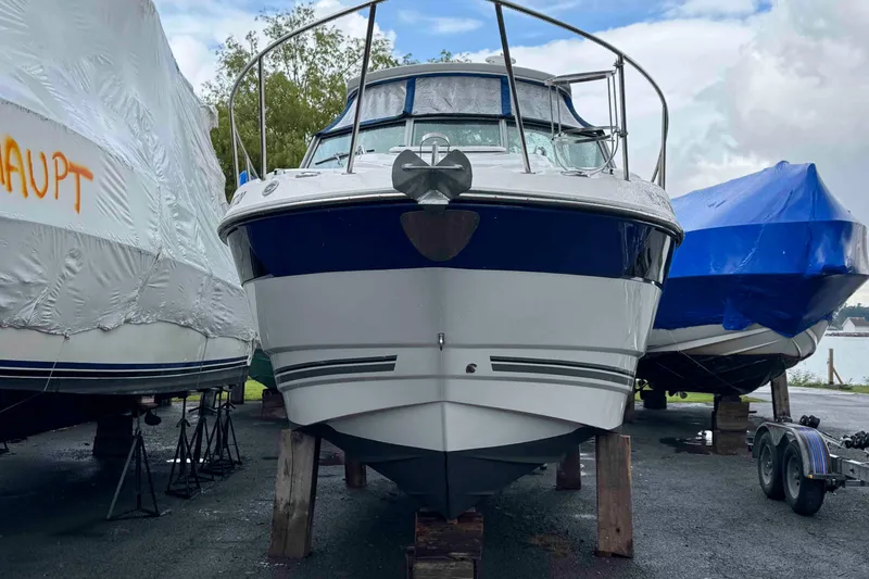 Slide: The Image of 2019 Monterey 295 Sport Yacht on blocks, surrounded by covered boats. - 1