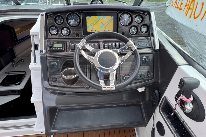 Slide: The Image of 2019 Monterey 295 Sport Yacht dashboard with steering wheel and navigation controls. - 10