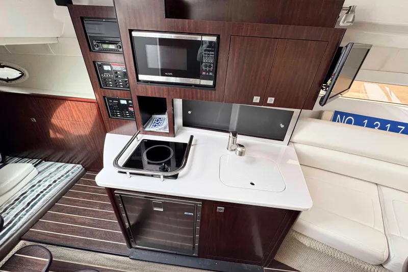 Slide: The Image of 2019 Monterey 295 Sport Yacht interior with kitchenette, microwave, and sink. - 17
