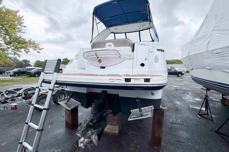 Slide: The Image of 2019 Monterey 295 Sport Yacht on blocks with blue canopy, ladder nearby. - 3