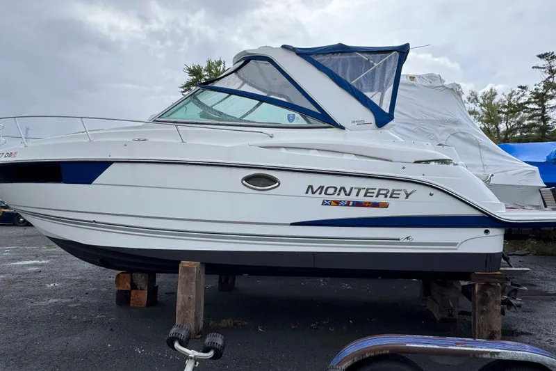Slide: The Image of 2019 Monterey 295 Sport Yacht on dry dock, side view with blue accents. - 4