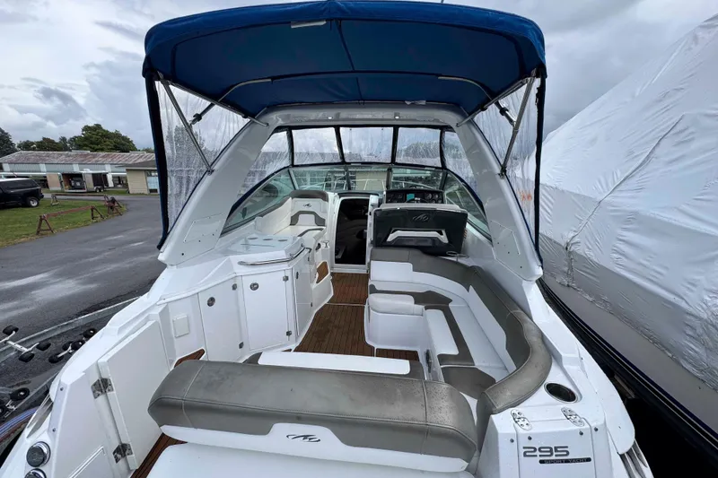 Slide: The Image of 2019 Monterey 295 Sport Yacht with blue canopy and spacious seating area. - 5