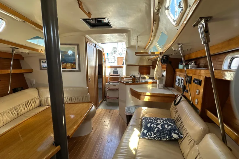Slide: The Image of Interior of a 1995 Catalina 320 sailboat with cozy seating and wooden finishes. - 15