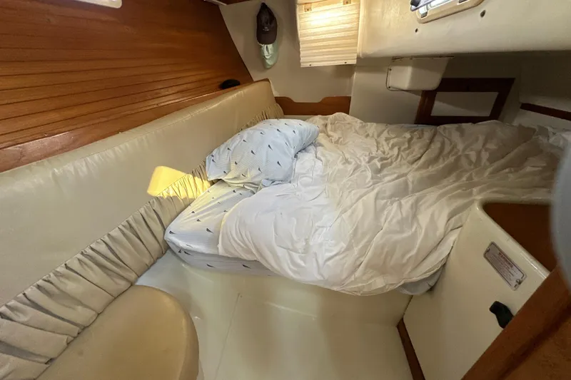 Slide: The Image of Cozy cabin interior of a 1995 Catalina 320 sailboat with a neatly made bed. - 18