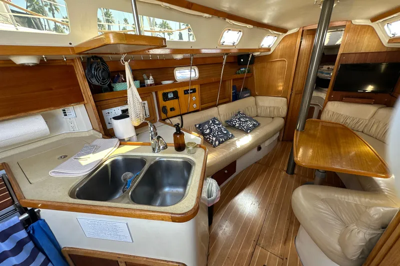 Slide: The Image of Interior of a 1995 Catalina 320 sailboat with cozy seating and kitchen area. - 2
