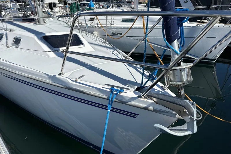 Slide: The Image of 1995 Catalina 320 sailboat docked in marina, featuring sleek design and sturdy anchor. - 24