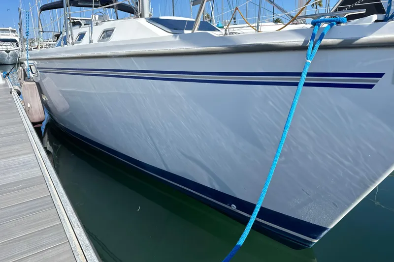 Slide: The Image of 1995 Catalina 320 sailboat docked with blue rope and sleek white hull. - 25