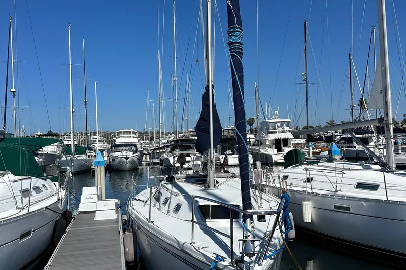 Slide: The Image of Marina with 1995 Catalina 320 sailboats docked under clear blue sky. - 27