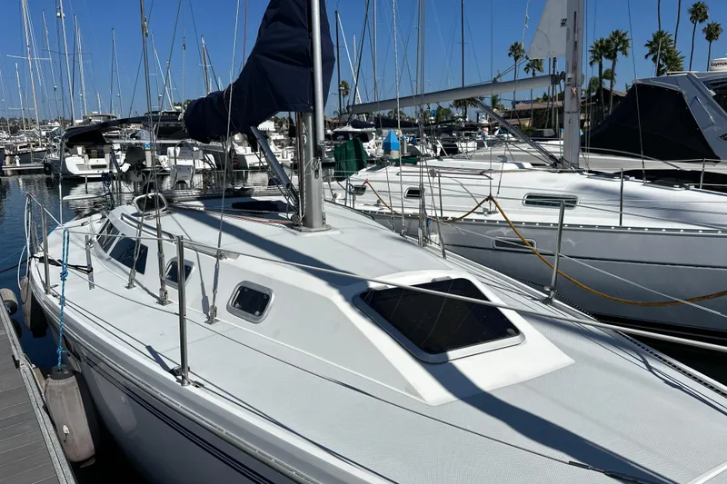 Slide: The Image of 1995 Catalina 320 sailboat docked in a marina, surrounded by other boats. - 28