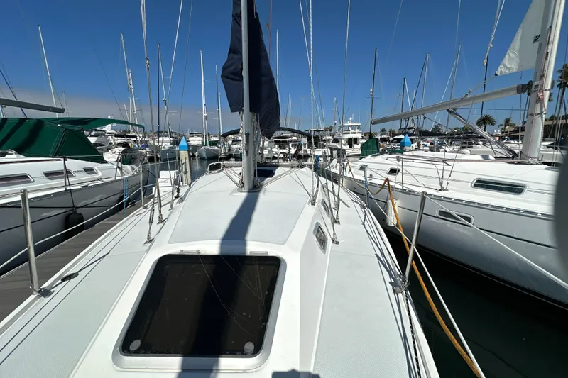 Slide: The Image of Sailboats docked at marina, featuring a 1995 Catalina 320 under clear blue skies. - 30