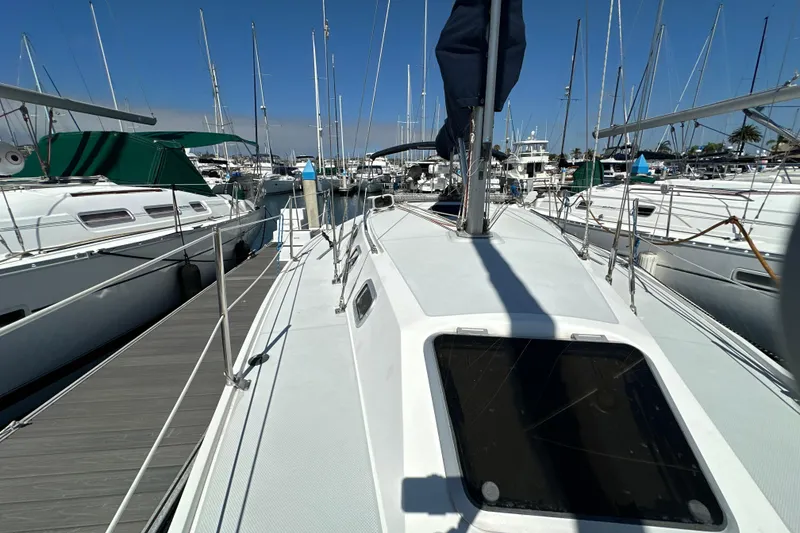 Slide: The Image of 1995 Catalina 320 sailboat docked in a marina, surrounded by other boats. - 31