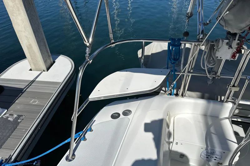 Slide: The Image of 1995 Catalina 320 sailboat docked, featuring a clean deck and stainless steel railings. - 34