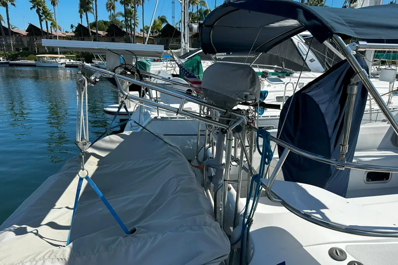 Slide: The Image of 1995 Catalina 320 sailboat docked in marina, featuring covered deck and rigging. - 36