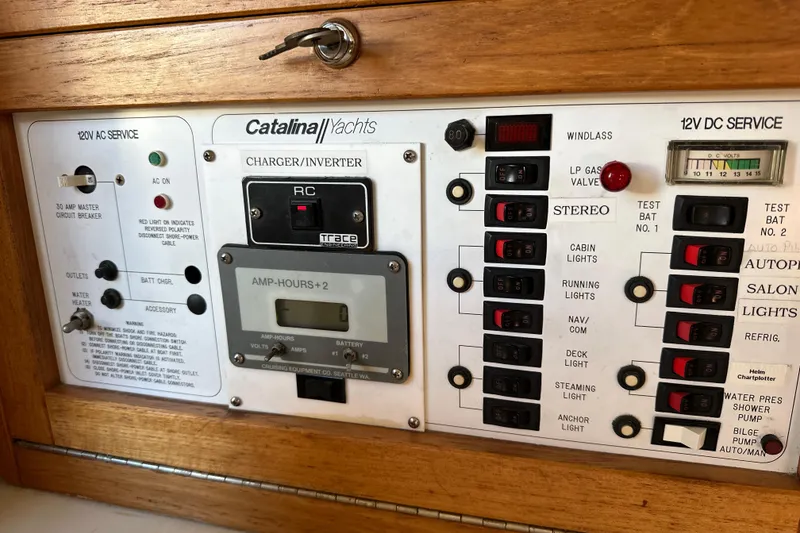 Slide: The Image of Electrical control panel of a 1995 Catalina 320 yacht with various switches and indicators. - 42