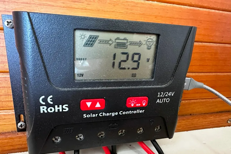 Slide: The Image of Solar charge controller displaying 12.9 volts, mounted on a Catalina 320, 1995 model. - 43