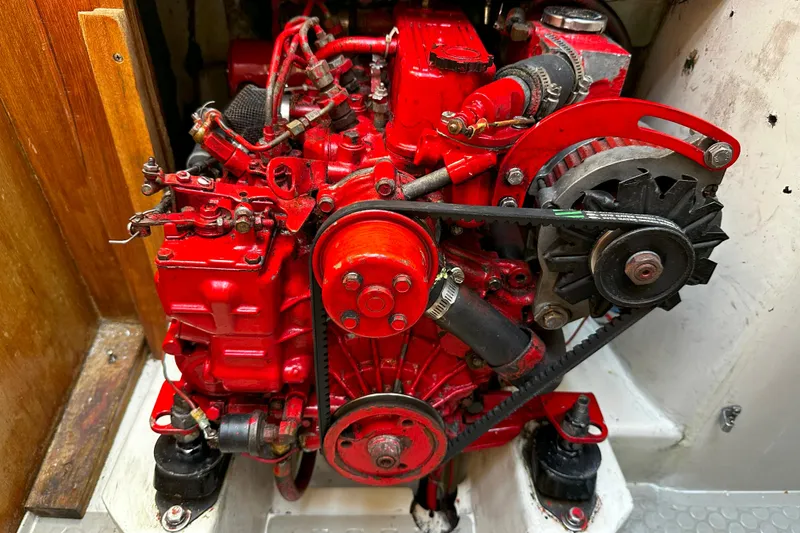Slide: The Image of Red engine of a 1995 Catalina 320 sailboat, showcasing detailed mechanical components. - 44