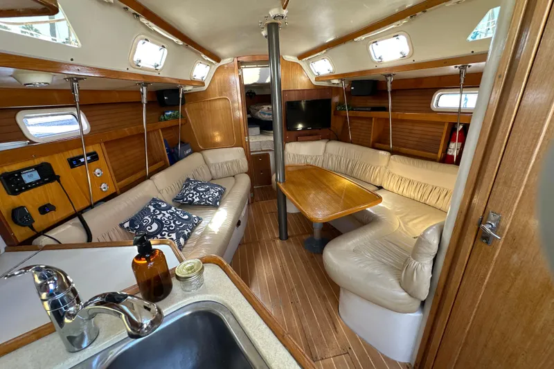 Slide: The Image of Interior of a 1995 Catalina 320 sailboat with cozy seating and wooden finishes. - 5