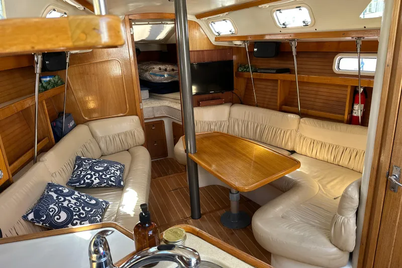 Slide: The Image of Interior of a 1995 Catalina 320 sailboat with cozy seating and wooden accents. - 6