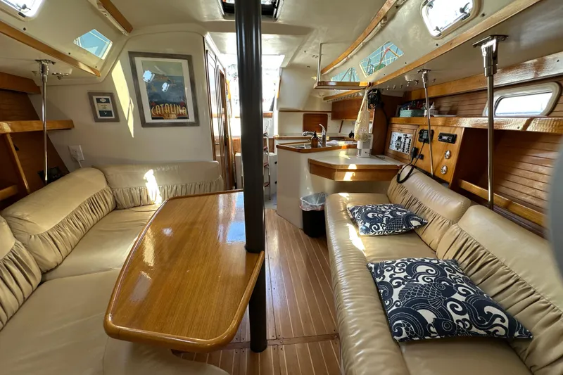 Slide: The Image of Interior of a 1995 Catalina 320 sailboat with cozy seating and wooden accents. - 9