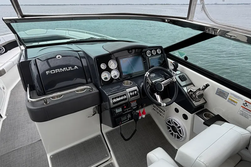 Slide: The Image of 2020 Formula 350 Crossover Bowrider cockpit with modern controls and steering wheel on water. - 35
