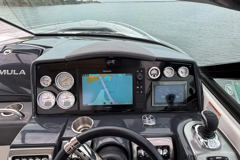 Slide: The Image of 2020 Formula 350 Crossover Bowrider dashboard with navigation and control instruments on a calm lake. - 37