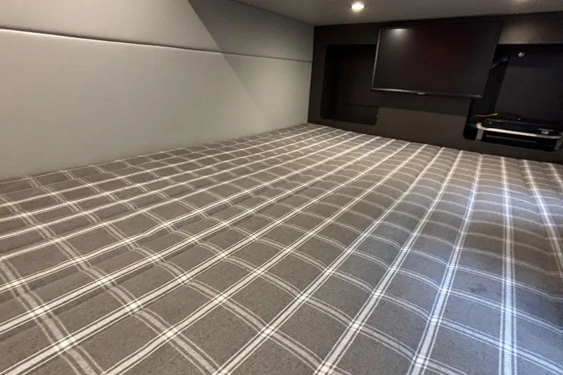 Slide: The Image of 2020 Formula 350 Crossover Bowrider interior cabin with plaid bedding and TV. - 50